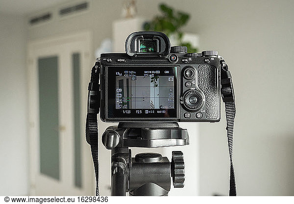 Close-up of digital camera on tripod in living room at home