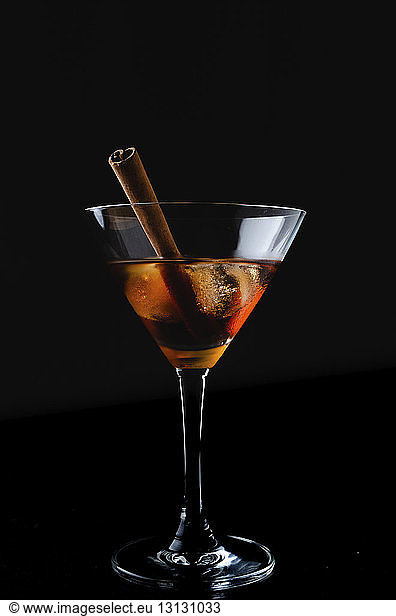 Close-up of drink in martini glass against black background