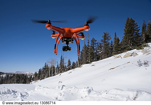 Close-up of drone flying over snow during winter