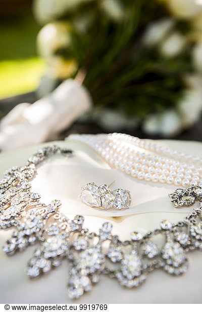Close-up of Earrings and Necklaces with Bridal Bouquet