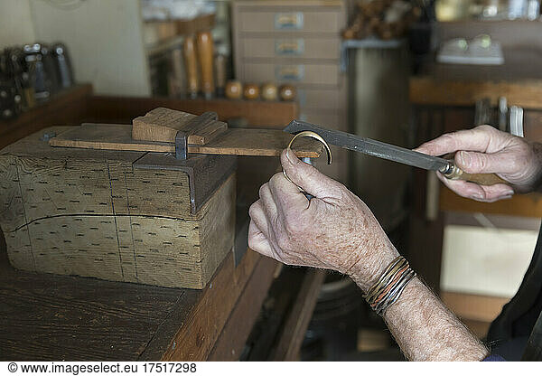 close-up of elderly caucasian hands making jewelry