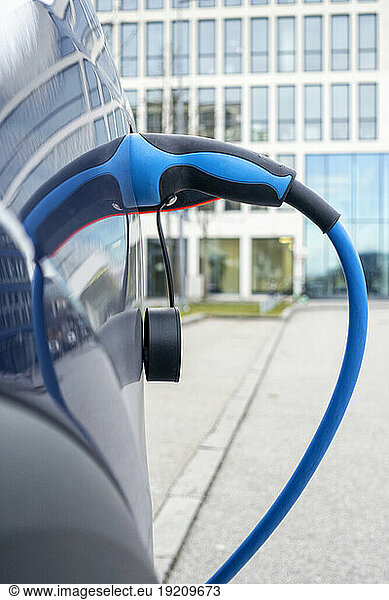 Close-up of electric car charging at station