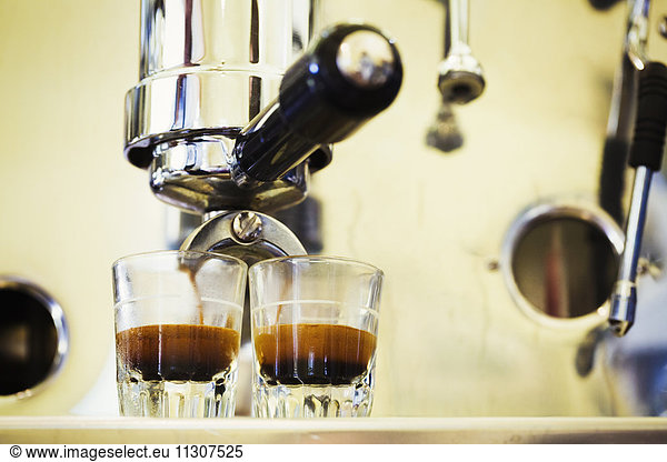 Close up of espresso machine and two glasses of espresso.