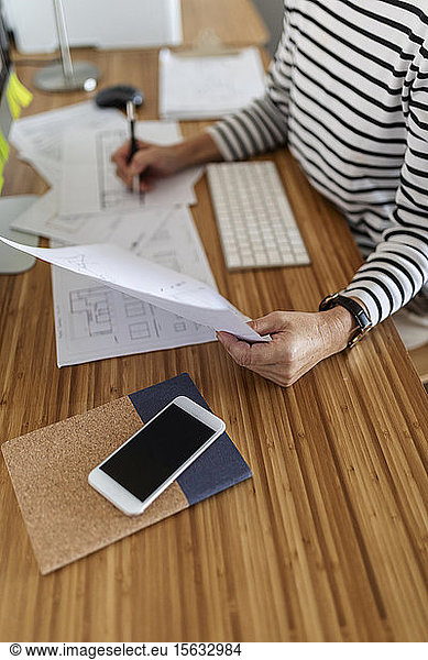 Close-up of female architect working on project in home office