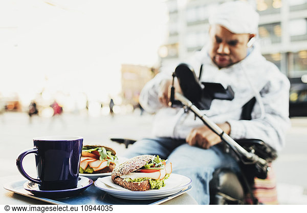Close-up of fresh meal served for disabled man at sidewalk cafe