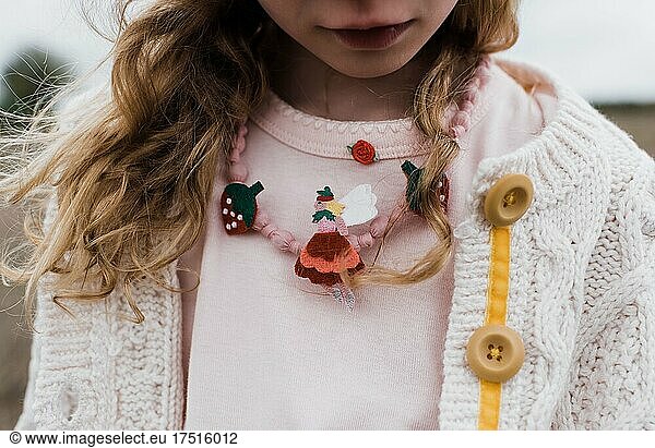 close up of girls fairy and strawberry necklace