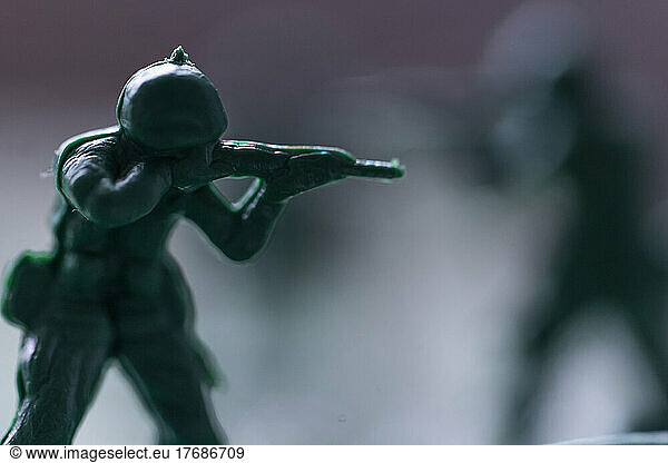 Close-up of green plastic toy soldier aiming rifle