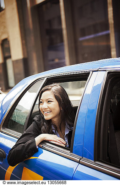 Close-up of happy businesswoman looking through car window