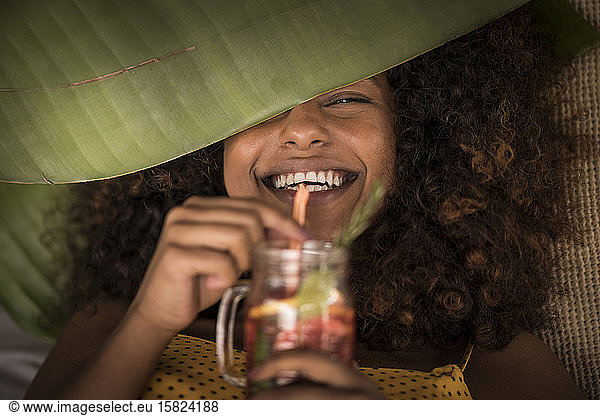 Close-up of happy woman drinking fresh ice tea drink