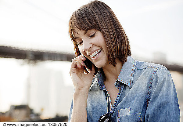 Close-up of happy woman using mobile phone