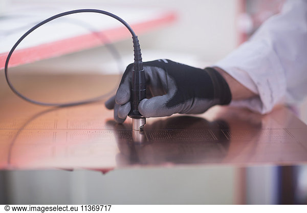 Close-up of human hand examining circuit board in industry  Hanover  Lower Saxony  Germany