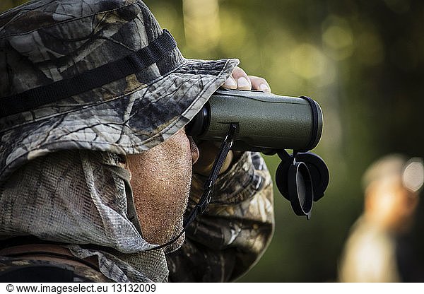 Close-up of hunter looking through binoculars