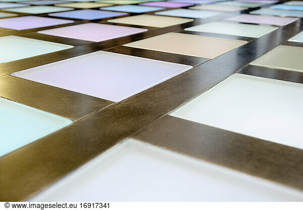 Close-up of illuminated multicoloured tiled dance floor  disco lighting.