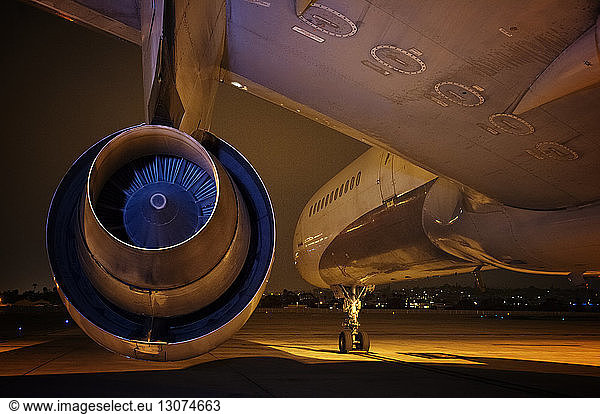 Close-up of jet engine at airport during night