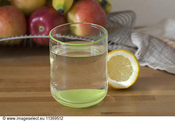 Close-up of lemon water with fruits in background