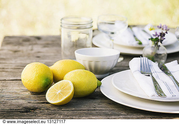 Close-up of lemons by plates on table