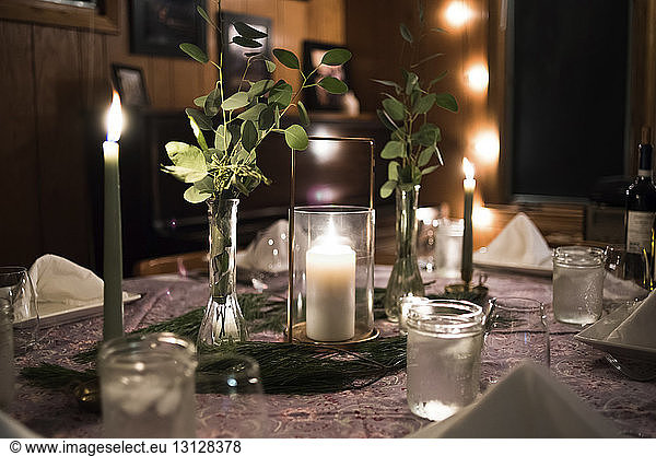 Close-up of lit candles decorated on dining table at home