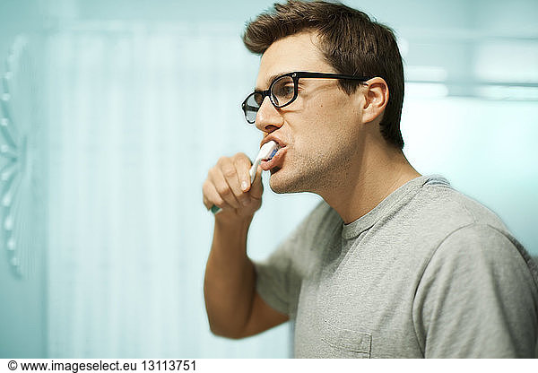 Close-up of man brushing teeth at home