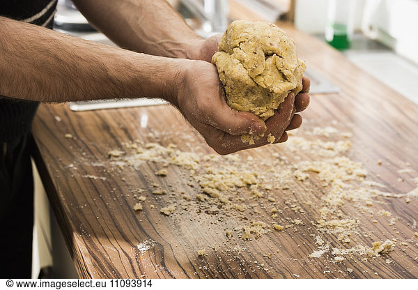 Close-up of man holding dough for preparing cookies