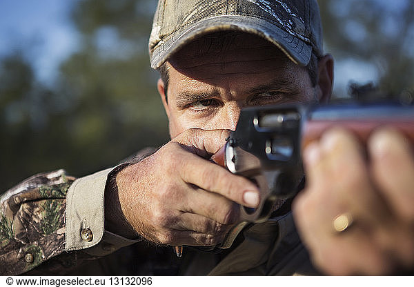 Close-up of man hunting with rifle
