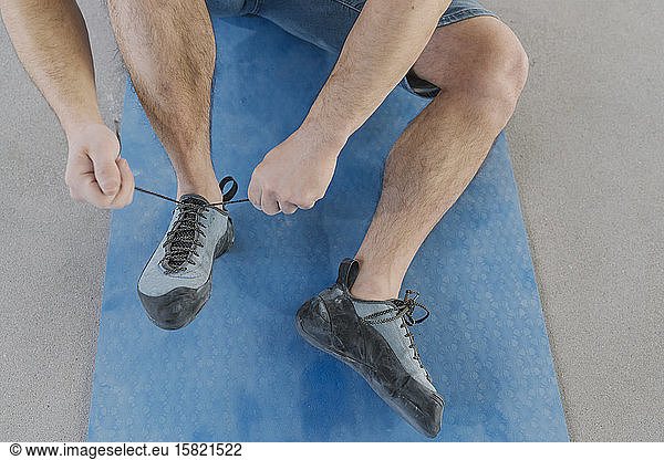 Close-up of man putting on climbing shoes