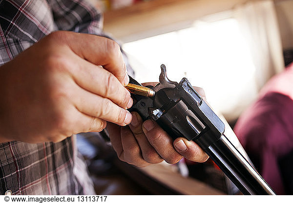 Close-up of man's hands loading revolver
