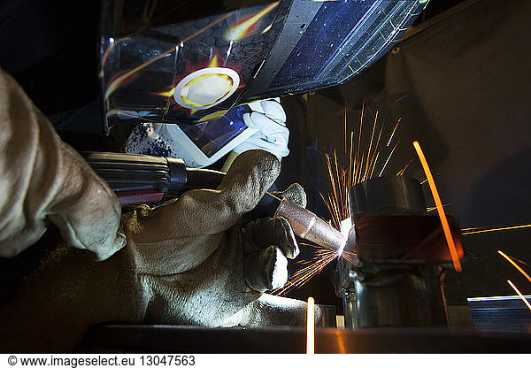 Close-up of manual worker using welding torch at workshop