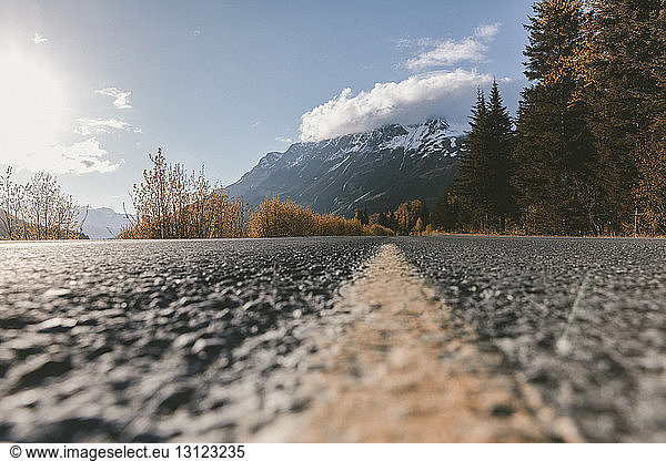 Close-up of marking on road against mountains and trees at Kenai Fjords National Park
