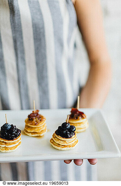 Close up of mini pancakes on serving platter.