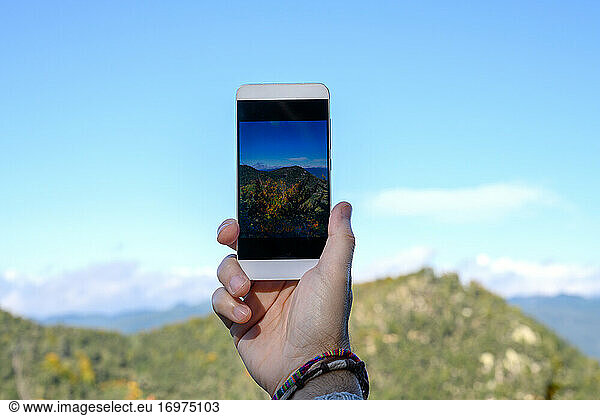 Close up of mobile phone in arms of man isolated on blurred background