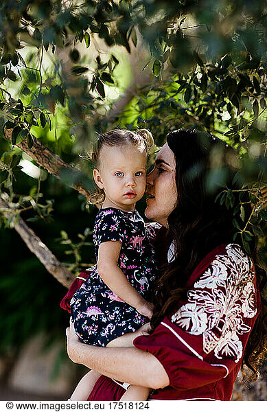 Close Up of Mom Holding Daughter Under Tree in California