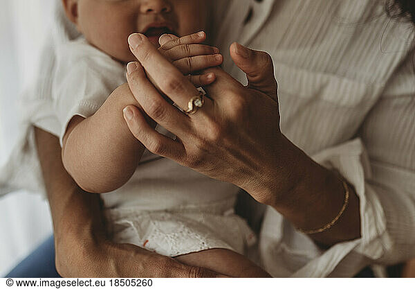 Close up of mother holding young daughter's fingers