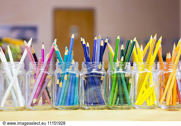 Close up of multicolor pencils organized in jars