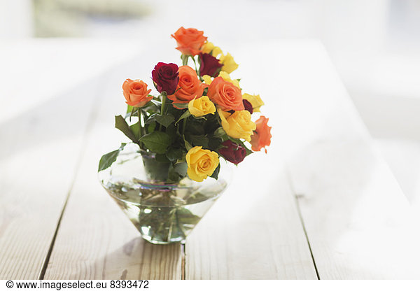 Close up of multicolor roses in vase on table