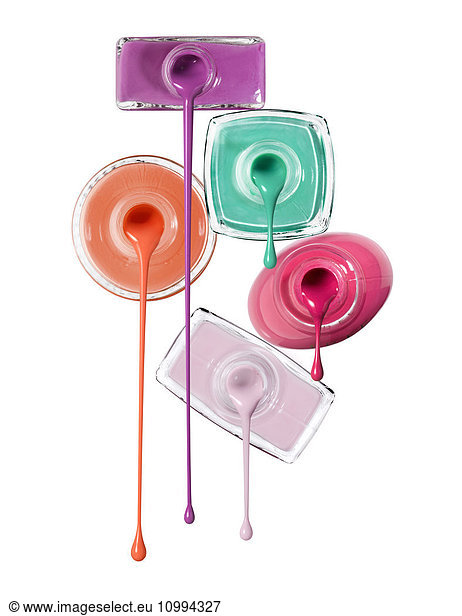 Close-up of Nail Polish Dripping from Bottles on White Background