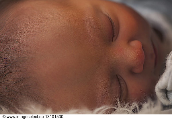 Close-up of newborn baby boy sleeping on fur