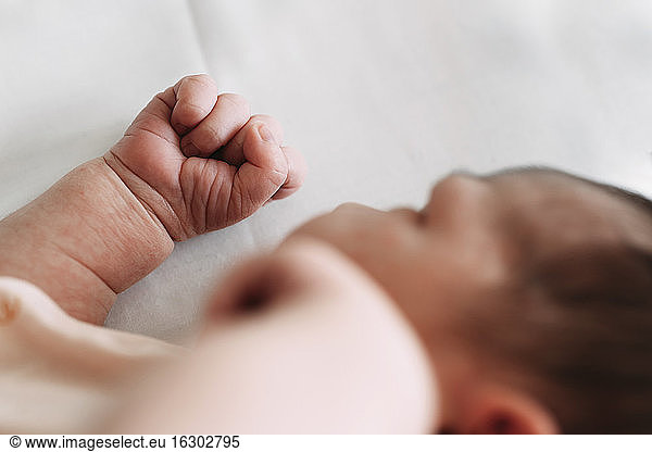 Close-up of newborn baby girl lying on bed in hospital