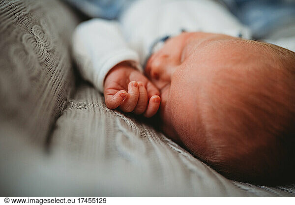 Close up of newborn baby's hand while sleeping in bed at home