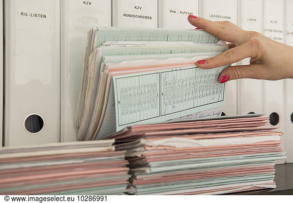 Close-up of nurse's hand searching medical records  Munich  Bavaria  Germany