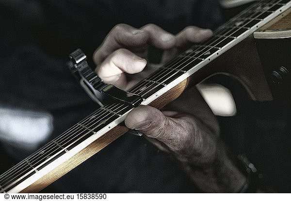 Close up of old hand playing an acoustic guitar