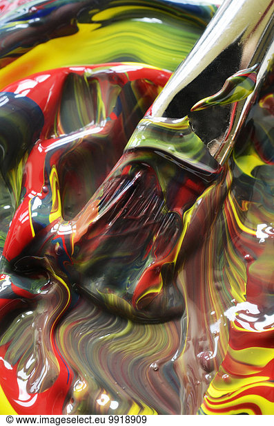 Close-up of paint swirls and brush