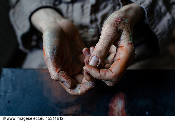 Close-up of painted hands of a female painter in her studio