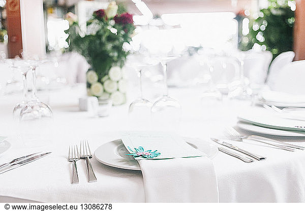 Close-up of plates and silverware arranged at restaurant table