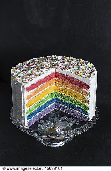 Close-up of rainbow cake against wall in studio