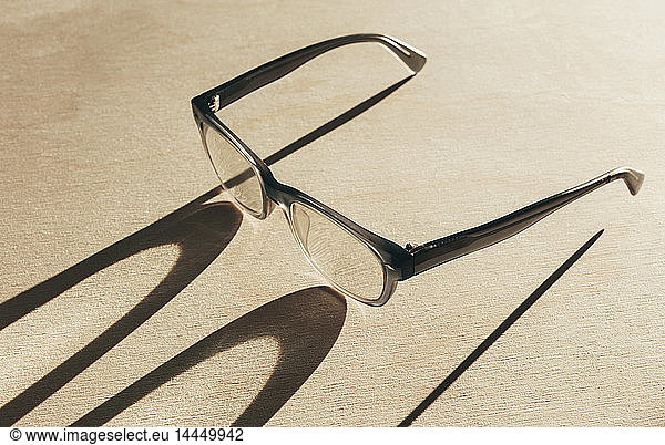 Close up of reading glasses casting long shadow