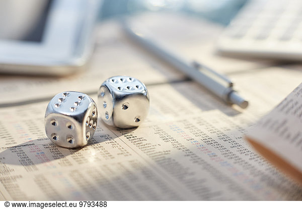 Close up of silver dice with sixes on messy desk