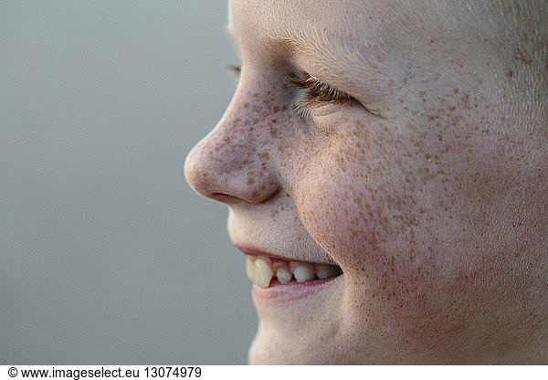Close-up of smiling boy with freckles at beach