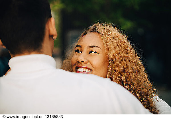 Close-up of smiling woman looking at friend outdoors