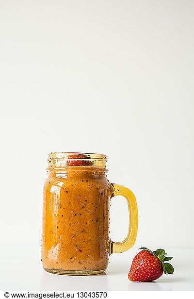 Close-up of smoothie in mason jar against white background