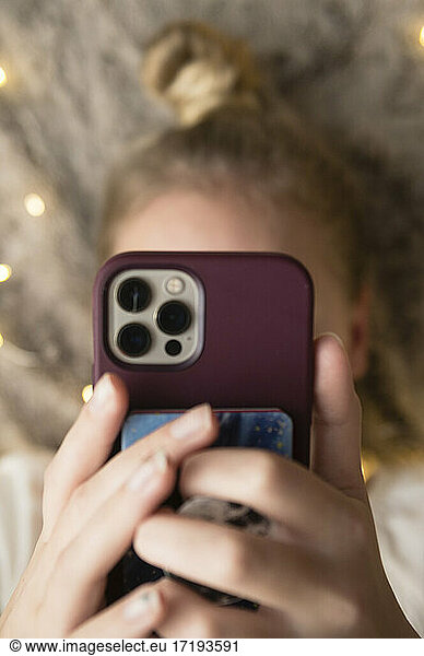 Close up of Teen/Tween Girl Laying Down Holding Mobile Phone